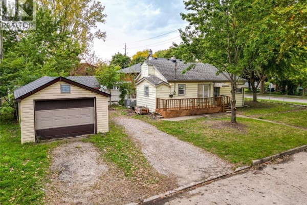 Front exterior of a beige bungalow with a covered porch and a driveway. - 3605 Bloomfield, Windsor