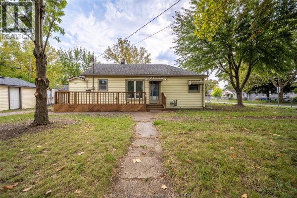 Front view of a beige bungalow with a walkway and a grassy front lawn. - 3605 Bloomfield, Windsor