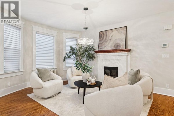 Living room with neutral sofas, coffee table, and dining area in the background. - 3607 7 Street Sw, Calgary