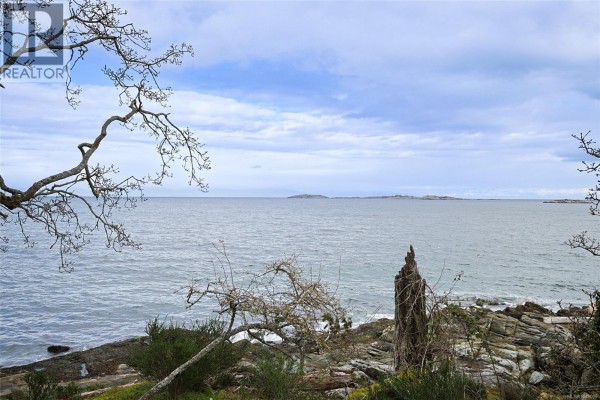 Overhead view of a house on a rocky point, surrounded by trees and ocean waves. - 3610 Outrigger Rd, Nanoose Bay