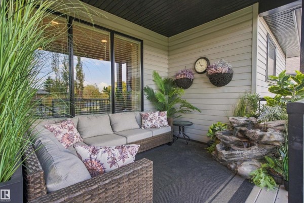 Covered patio with wicker sectional sofa and a small water feature. - 3611 61 St, Beaumont