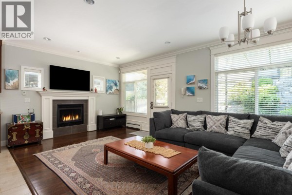 Living room with grey sofas, armchairs, coffee table, and a large patterned rug. - 362 E 21st Street, North Vancouver