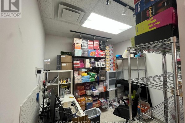 Small utility room with electrical panels, printer, shelves with supplies, and exposed conduits. - 3623 Highway 7, Markham