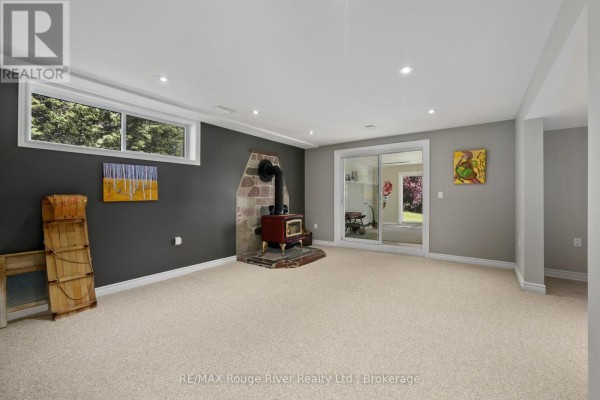 Wood-burning stove and sliding glass door in basement - 3625 Alnwick Hill Road Hamilton Township