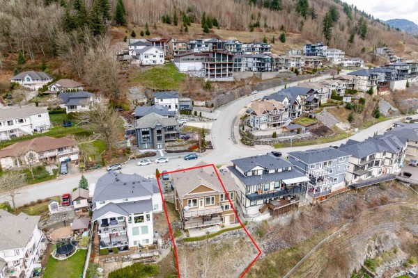 Living room featuring a stone fireplace, large windows, and a view of the landscape. - 36390 Epworth Court, Abbotsford