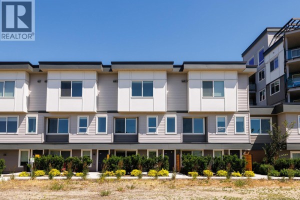 Exterior view of the modern townhouse complex with multiple windows and balconies. - 3642 Mission Springs Drive Unit# 103, Kelowna