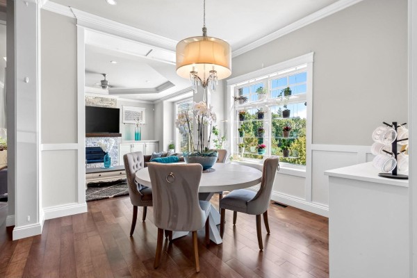 Dining room with a round table, velvet chairs, a chandelier, and hardwood floors. - 36497 Carnarvon Court, Abbotsford