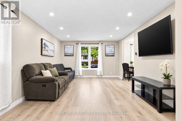 Living room and dining area with laminate flooring, sofas, a television, and dining table. - 365 Blue Forest Drive, London North