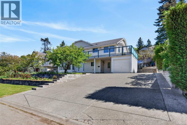 Front view of a white two-story house with a long driveway and green lawn. - 365 Panorama Cres, Courtenay