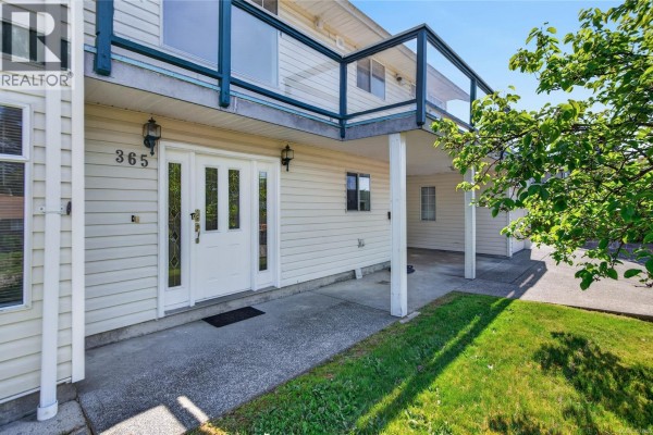 Front entrance of a white house with double doors, glass panels, and a concrete walkway. - 365 Panorama Cres, Courtenay