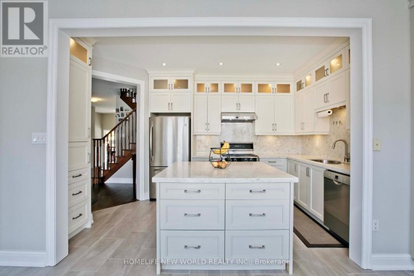 View of an open-concept kitchen with white cabinetry, quartz countertops, and a large island. - 365 Tonelli Lane, Milton