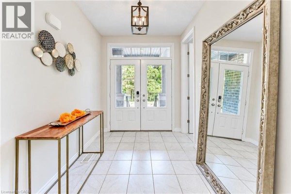 Foyer with white tiled floor, double front doors, console table, and large ornate mirror. - 365 Woolwich Street, Waterloo