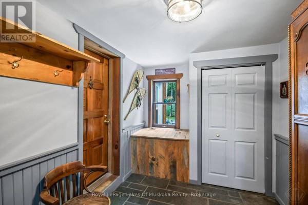 Interior foyer with wood trim, coat hooks, snowshoes, and a wooden storage bench. - 3650 Muskoka Road 117, Lake Of Bays