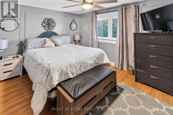 Bedroom with king bed, paneled walls, ceiling fan, TV, dresser, and bench - 366 Burlington Crescent London South