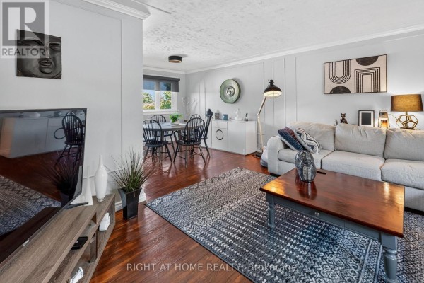 Living and dining area with dark wood floors, a dining table, and sofa. - 366 Burlington Crescent, London South