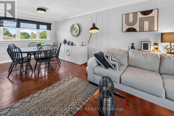 Dining area and living room with hardwood floors and patterned rug. - 366 Burlington Crescent, London South