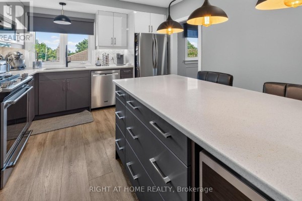 Modern kitchen with island, quartz counters, stainless steel appliances, and pendant lights - 366 Burlington Crescent London South