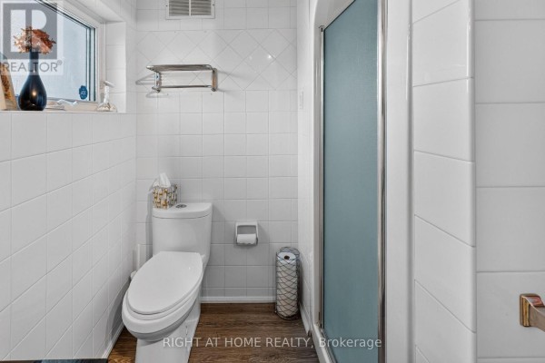 Toilet and shower stall in a bathroom with tiled walls - 366 Burlington Crescent London South