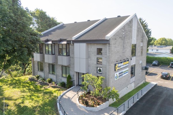 Angle view of commercial building exterior with grey brick and landscaping. - 366 Ch. D'aylmer, Gatineau