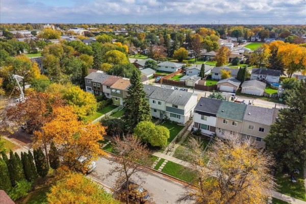 Aerial view of townhouses in a neighborhood with autumn trees. - 366 Houde Drive, Winnipeg