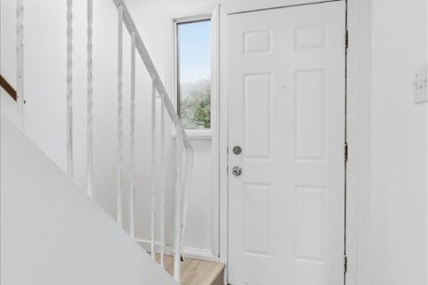 Interior view of a white front door and staircase with white railings. - 366 Houde Drive, Winnipeg