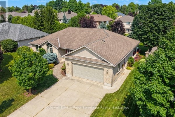 Side aerial view of a brick bungalow with a paved driveway and green lawn. - 366 Westwood Drive, Brockton