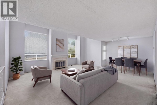 Living and dining area with a fireplace, beige carpet, and neutral-toned furniture. - 3661 Handel Avenue, Vancouver