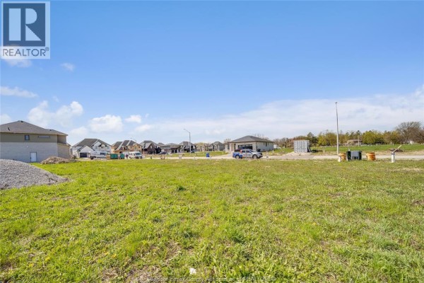 Grassy lot featuring utility markers and houses in various stages of completion. - 3662 Farrow Avenue, Windsor