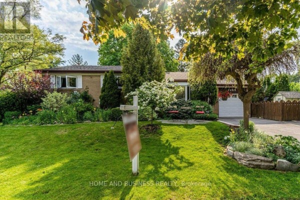 Front exterior of a brick bungalow with a manicured lawn, mature trees, and a driveway. - 3668 The Credit Woodlands Road, Mississauga