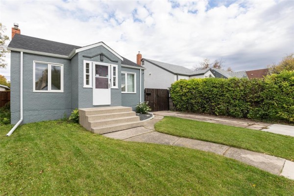 View of the front of a grey house with a white door, concrete steps, and driveway. - 367 Jamison Avenue, Winnipeg