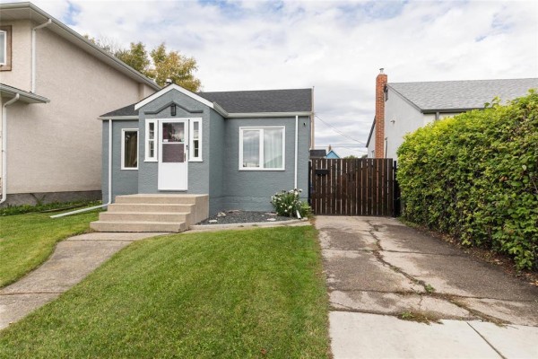 The grey exterior of a house with a front door, walkway, and a lush green hedge. - 367 Jamison Avenue, Winnipeg