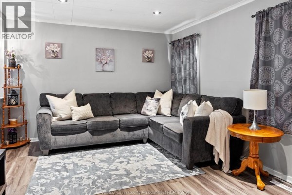 Living room with a large sectional sofa, side table, and decorative wall art. - 3672 Girardot, Windsor