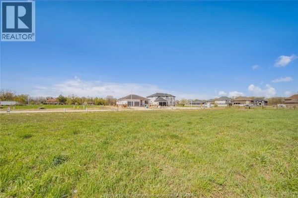 Green field with a few houses under construction in the distance. - 3673 Farrow Avenue, Windsor