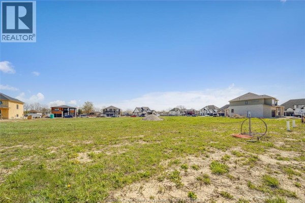 Empty lot with some construction materials and new homes visible. - 3673 Farrow Avenue, Windsor