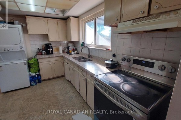 Kitchen with light-colored cabinets, granite countertops, stainless steel appliances, and tile flooring. - 3677 Woodruff Crescent, Mississauga