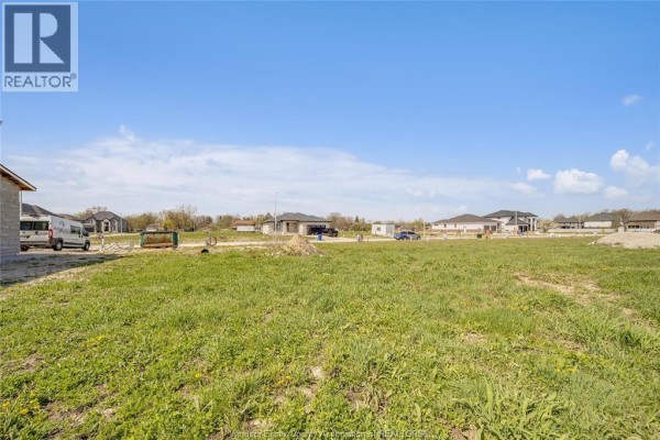 Green vacant land with scattered houses under construction and completed homes in the distance. - 3679 Farrow Avenue, Windsor