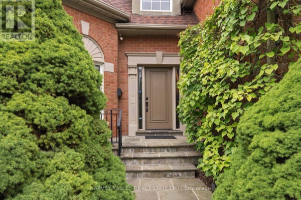 Stone walkway leading to a covered front entrance with a brown door. - 3685 St. Laurent Court, Mississauga