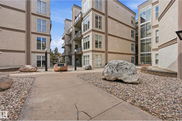 View from the apartment entrance showing an open-concept living area with a kitchen island. - #369 4823 104a St Nw, Edmonton