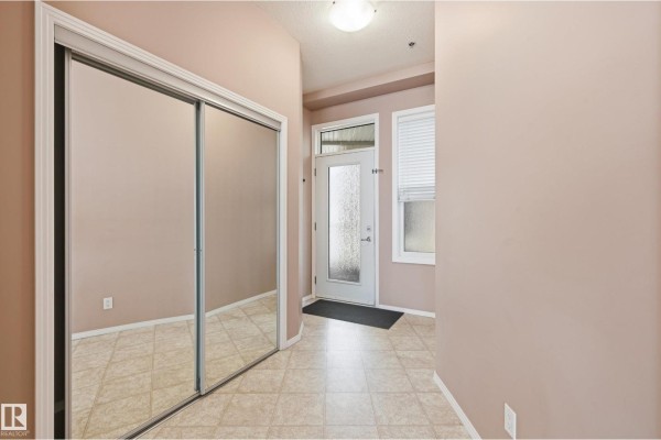 Living room with beige carpet, sofa, coffee table, accent chair, and large windows. - #369 4823 104a St Nw, Edmonton