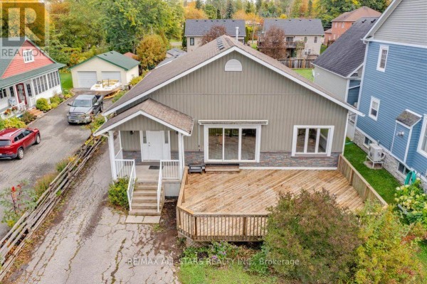 Aerial view of a grey house with a wooden deck and attached garage. - 369 Lake Drive, Georgina