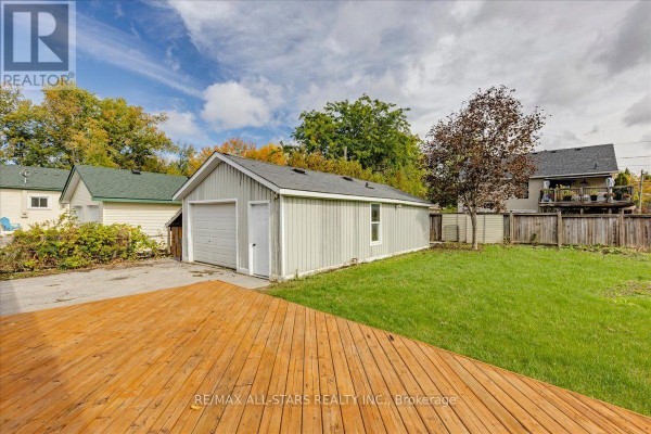 Backyard of the house with a wooden deck and a two-car garage. - 369 Lake Drive, Georgina