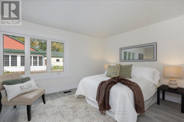 Bedroom with a queen-size bed, large window, and light grey flooring. - 369 Lake Drive, Georgina