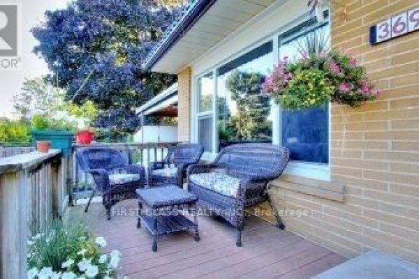 Close-up of a covered front porch with wicker furniture and hanging flower baskets. - 369 Paliser Crescent S, Richmond Hill