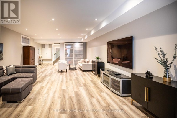 Spacious living room with sectional sofa, large TV, and modern decor - 36b Pine Avenue Mississauga