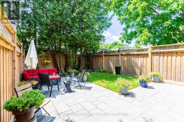 Backyard with patio furniture, lawn, and fence - 123 Maple Street Toronto
