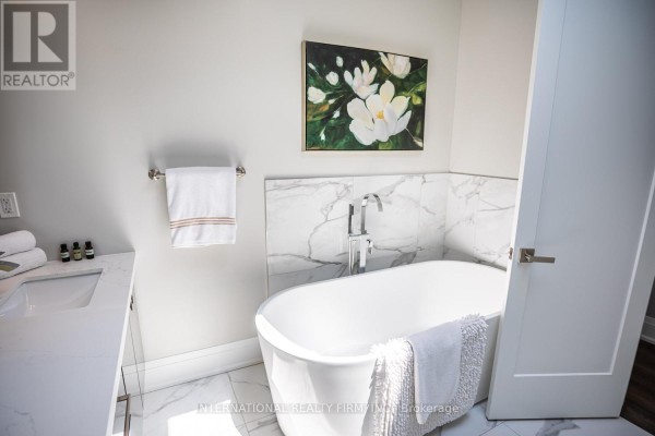 Freestanding bathtub and vanity sink in a modern bathroom with marble accents - 36b Pine Avenue Mississauga