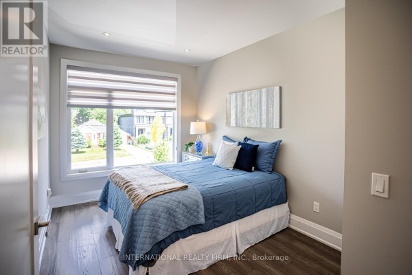 Bedroom with blue bedding, accent art, and large window - 36b Pine Avenue Mississauga