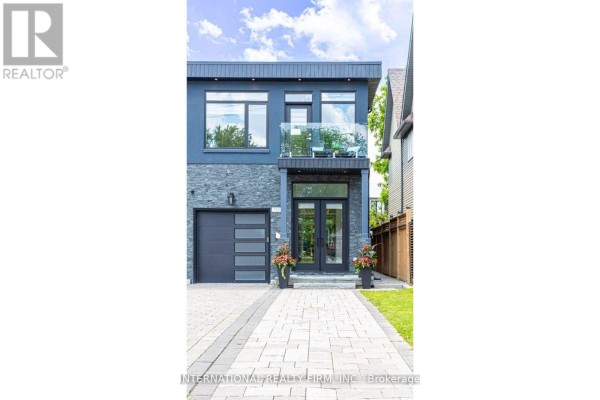 Modern house with stone facade, glass balcony, and contemporary garage door - 36b Pine Avenue Mississauga