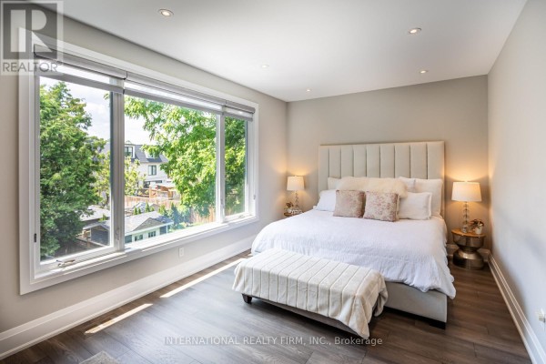Bedroom with large windows, upholstered headboard, and bench - 36b Pine Avenue Mississauga