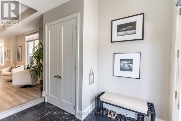 Hallway with double doors, artwork, bench, and shoe rack - 36b Pine Avenue Mississauga